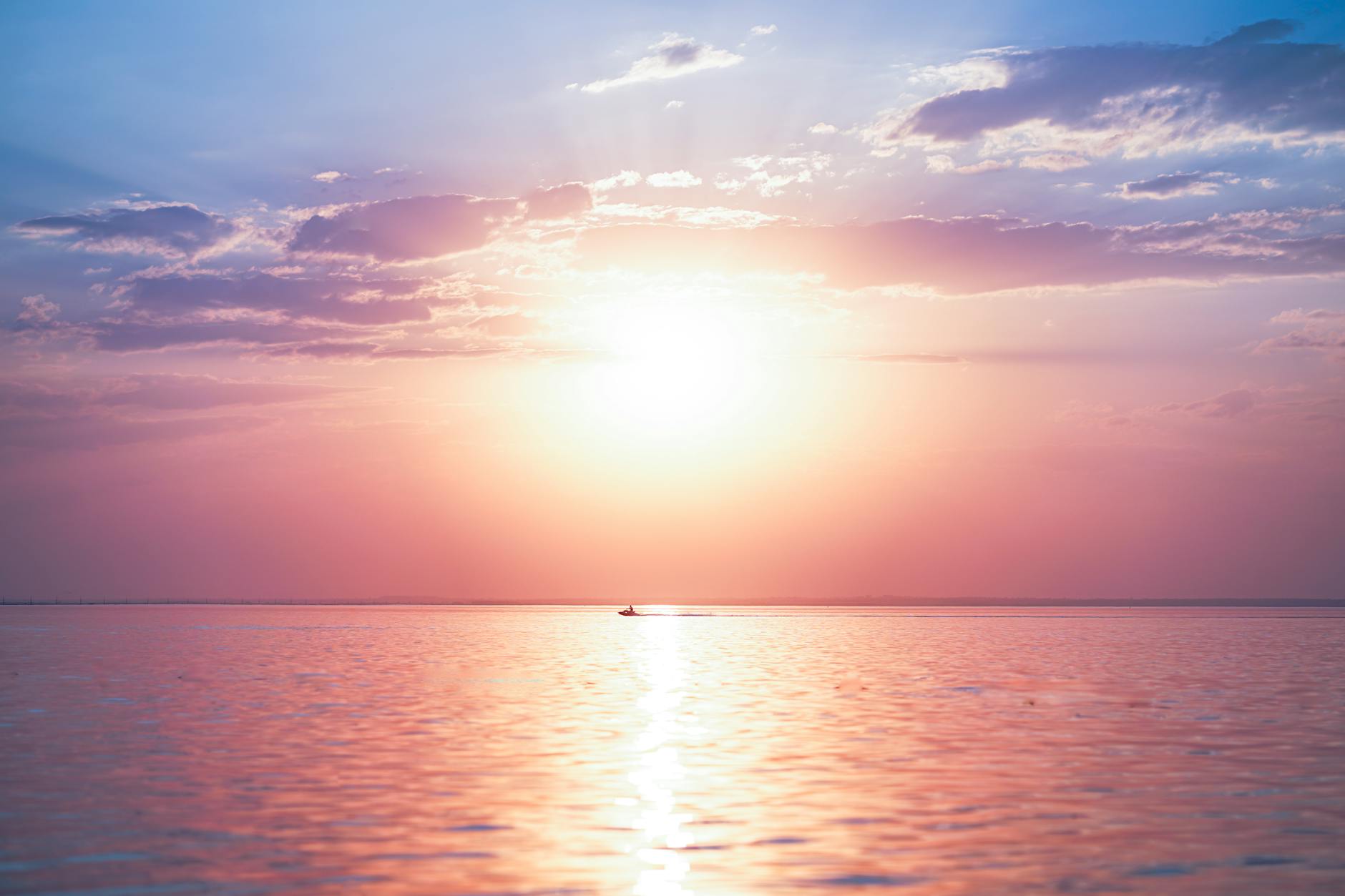 Serene sunrise over peaceful ocean with blue and teal waters